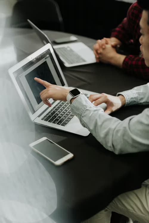 Two colleagues collaborating on a laptop